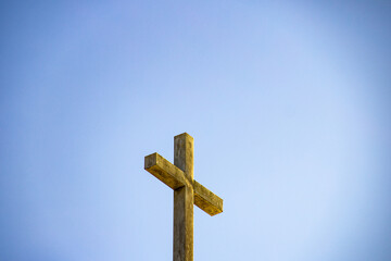 Cruz sobre uma igreja com céu azul ao fundo. (Igreja Nossa Senhora da Assunção). 