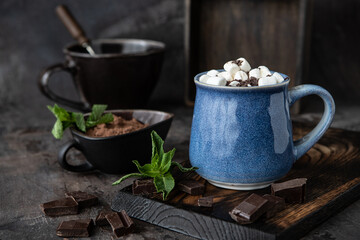 Fototapeta na wymiar Thick spicy hot chocolate in ceramic cup on rustic background