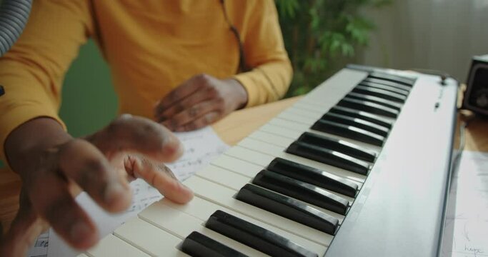 Crop black man playing music for piano