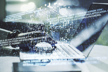 Double exposure of creative code skull hologram and hands typing on laptop on background. Malware and cyber crime concept
