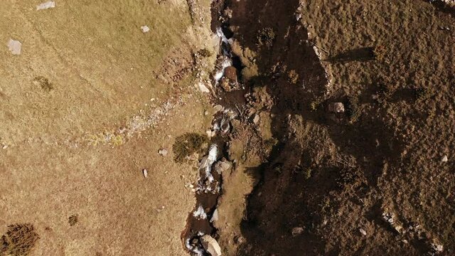 Aerial view of natural waterfall, mountain valley with serpantine road, Andorra