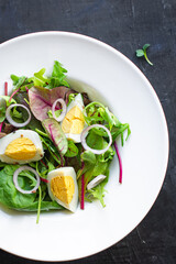 egg salad vegetables fresh green leaves mix spinach, arugula, lettuce, eggs boiled organic food healthy meal snack copy space food background top view veggie vegetarian keto or paleo diet