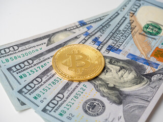 yellow bitcoin lies on hundred-dollar bills. The concept of cryptocurrency, investment, income