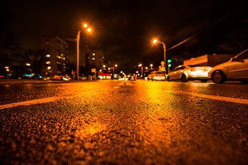 Rainy night in the big city, busy crossroad. View from a wide angle at the level of the double...