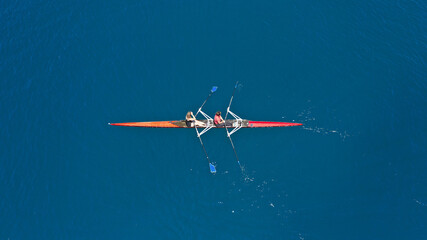 Aerial drone top down photo of sport canoe operated by team of young women in emerald calm sea...