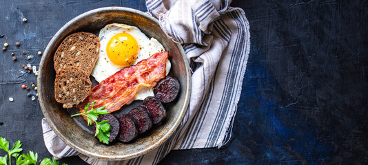 english breakfast fried egg fresh black pudding blood sausage, cereal bread, beans, bacon,...