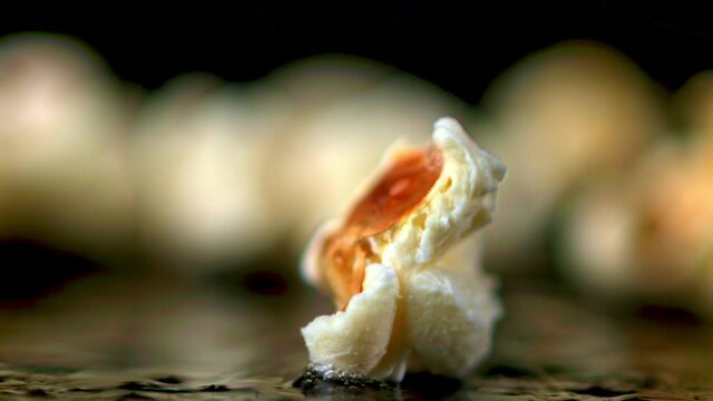 The super slow motion of the popcorn grain explodes. On a black background.Filmed on a high-speed camera at 1000 fps. High quality FullHD footage
