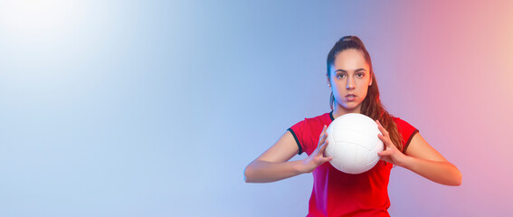 Volleyball girl hold and kick ball on neon background. Player doing sport workout at home. Sport...