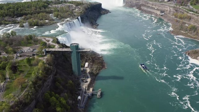 Flying above Niagara Falls and observation tower. Sunny day with boat on the Niagara River