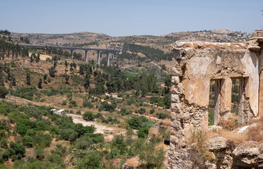 Fototapeta na wymiar View on a modern railway bridge for fast trains connecting Jerusalem with Tel-Aviv from an a abandoned Arab village Lifta on the outskirts of Jerusalem. National nature reserve Lifta.