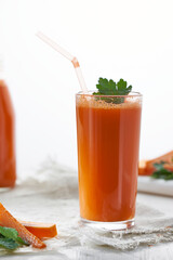 Carrot juice and slices of fresh carrot on white background.