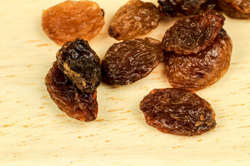 Sultana raisins on brown wooden board
