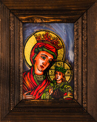 Obraz premium Framed icon painted on reverse glass in the naive orthodox style of Eastern Europe depicting Virgin Mary and baby Jesus.