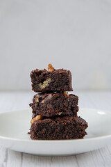 The concept of sweetness, useless food. Pyramid of three pieces of chocolate brownie.