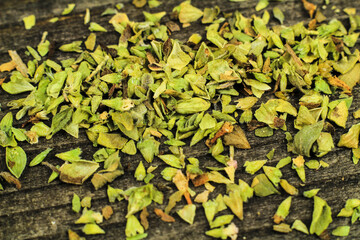 Crushed dried oregano on wooden board