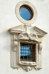 a window frame in the shape of a face with a open mouth as the window in the city of Rome, Italy 