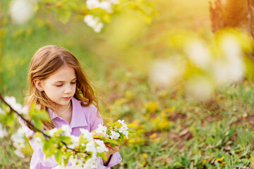 Beautiful kid girl with a branch of a flowering tree. natural cosmetics