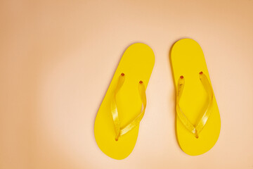 yellow slippers on a sand-colored background. Copy space