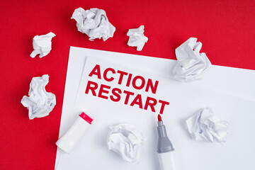 On a red background lies crumpled paper, a marker and a sheet of paper with the inscription -...