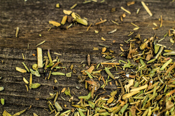 Dried thyme spilled on gray wooden board