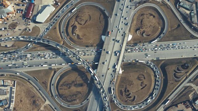 Roundabout with cars, view from the top. Beautiful panorama of the highway in the evening at sunset. Countryside landscape, advanced innovation concept, transport logistics.