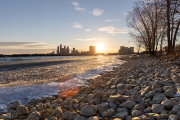 Full moon rising above a tall stone lighthouse - shallow depth of field shot through a blurry wooden beach fence. Fire Island, Long Island New York