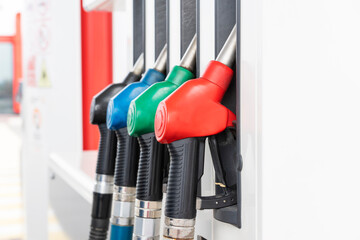 Four handles of fuel hoses on gas station ready for refueling cars. Equipment for fueling gas,...