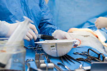 Breast augmentation under the guidance surgeons team in surgical operating room.