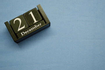 Wooden calendar from blocks on a blue background. Twenty first of December