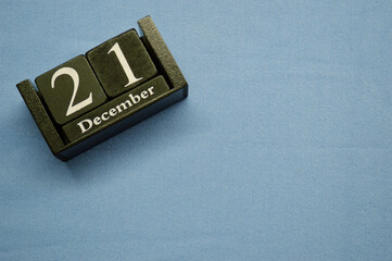 Wooden calendar from blocks on a blue background. Twenty first of December