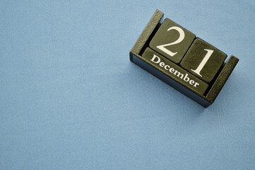 Wooden calendar from blocks on a blue background. Twenty first of December