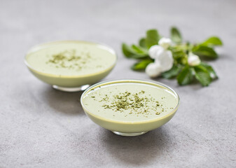 Panna Cotta green matcha tea in a glass bowl on a light gray background