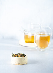 Japanese green tea Genmaicha.Tea leaves with fried brown rice on a bright gray background with a shadow.Slimming trend tea concept. a cup of tea. brew a transparent teapot