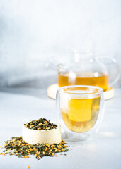 Japanese green tea Genmaicha.Tea leaves with fried brown rice on a bright gray background with a shadow.Slimming trend tea concept. a cup of tea. brew a transparent teapot
