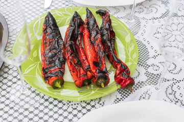 Close up view of grilled paprika on green plate. 
