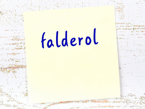 Yellow sticky note on wooden wall with handwritten word falderol