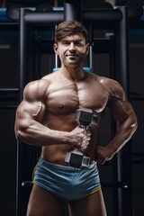 Fototapeta na wymiar athletic man exercising pumping up biceps muscles