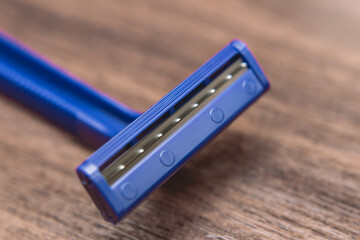 close-up of a blue razor on a wooden table