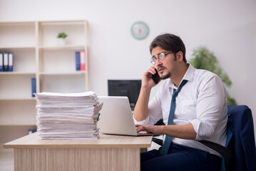 Naklejka premium Young male employee unhappy with excessive work in the office