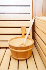 Fototapeta na wymiar Close up of wooden bucket with ladle in sauna