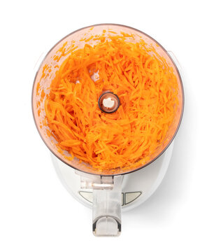 Carrots Shredded In Food Processor, Top View. Kitchen Gadget To Process Large Amount Of Food In Uniform Sizes. Concept For Healthy Meal Prep And Make-ahead Meals. Isolated On White. Selective Focus.