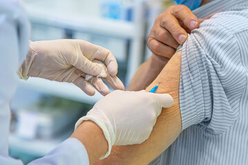 COVID-19 Vaccination concept. Doctor in rubber gloves injecting syringe with vaccine. Close up with selective focus