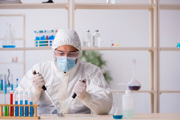 Young male chemist working at the lab during pandemic
