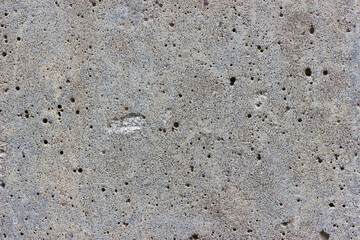 A flat grey concrete textured surface covered in lots of air bubbles