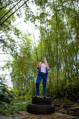 Vertical shot of a Hispanic woman with blonde hair standing on black tires