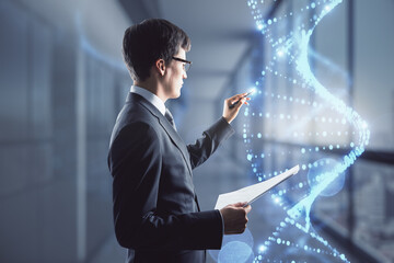 Bioengineering concept with man in black suit writing on virtual dna strand.