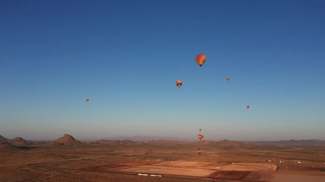 Aerial view of many hot air balloons flying over Arizona landscape