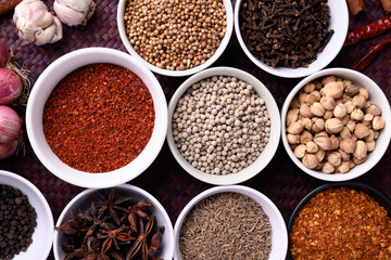 Various dry spices and herbs in a bowl. Asian food ingredients (chili, clove, caraway, coriander seed, star anise, cardamom, pepper, cinnamon, garlic and shallot)