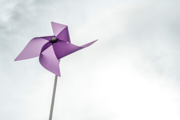 Image with a lot of empty space and purple pinwheel on the left with blades stopped