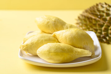 Ripe Thai durian fruit (Monthong) on plate with yellow background, Tropical fruit